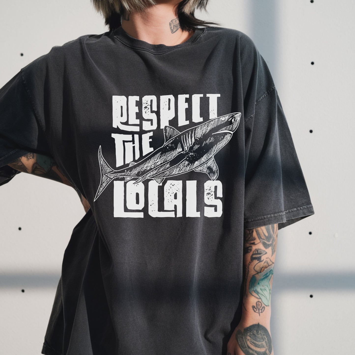 Vintage beach t-shirt featuring a shark print and "Respect the Locals" text. Perfect ocean conservation shirt for surfers, nature lovers, and coastal lifestyle fans. Unisex graphic tee with laid-back retro style.
