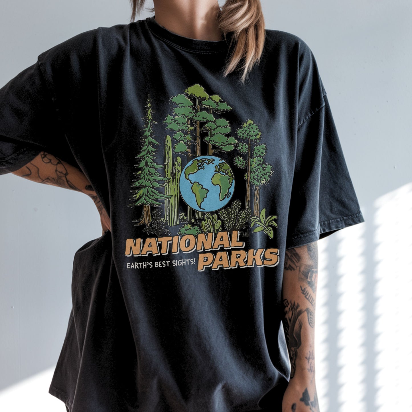 Person wearing a black t-shirt with a 'National Parks' graphic design.