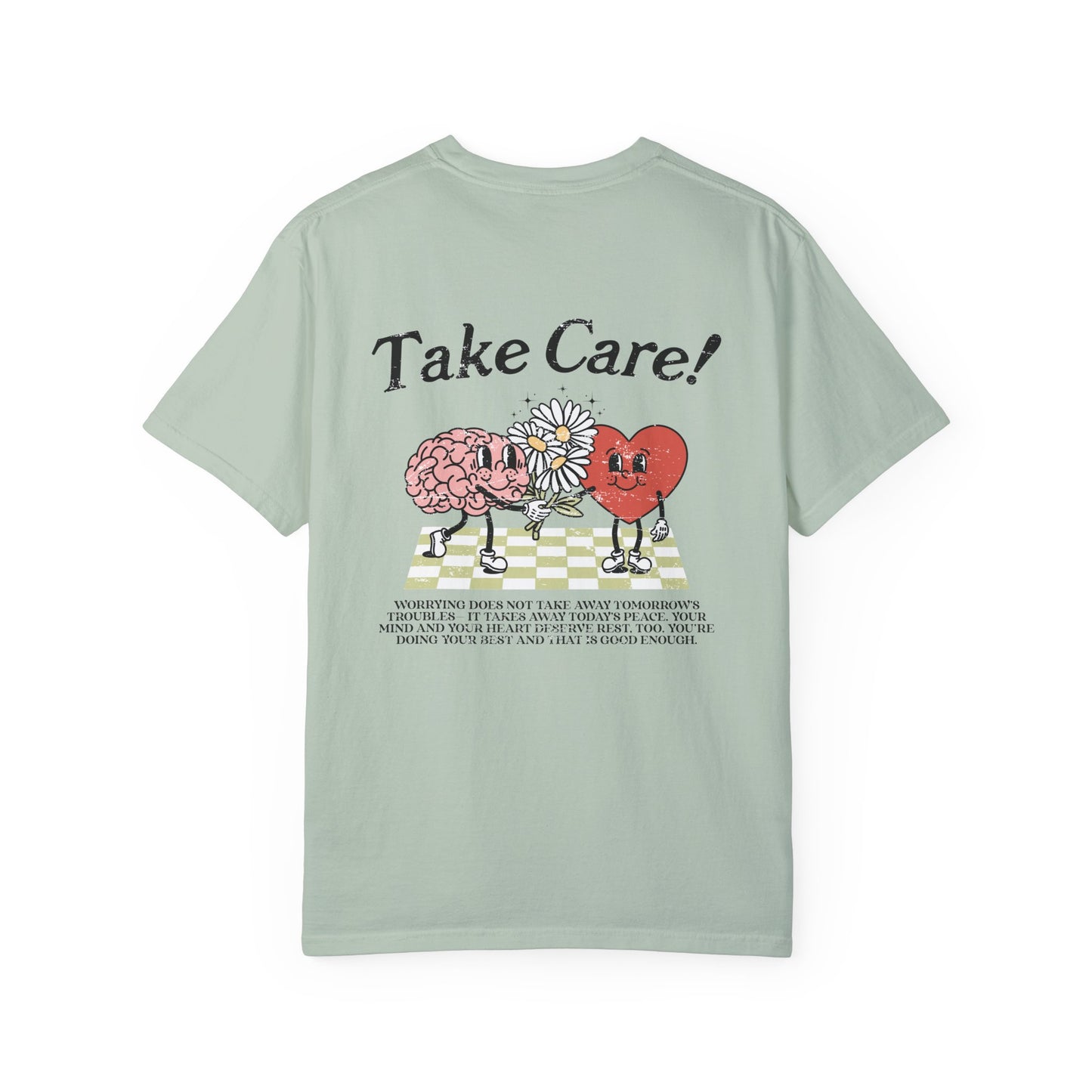 Graphic tee featuring a whimsical design with a heart and brain holding a flower, paired with motivational text encouraging self-care and positivity. Perfect for mental health awareness and retro-inspired casual style.
