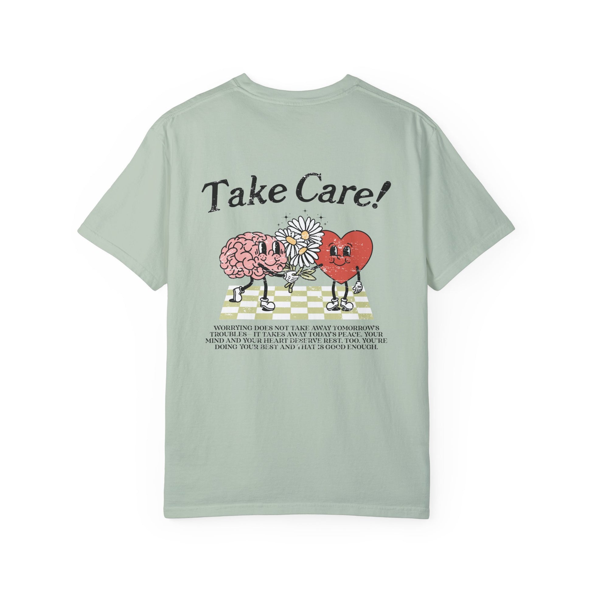 Graphic tee featuring a whimsical design with a heart and brain holding a flower, paired with motivational text encouraging self-care and positivity. Perfect for mental health awareness and retro-inspired casual style.