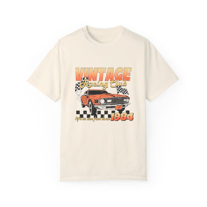 Retro racing T-shirt featuring a bold 1984 vintage design with distressed car graphics. Perfect nostalgic car shirt for muscle car lovers, featuring checkered flag details. Ideal for fans of old school racing and fast lane graphic tees.