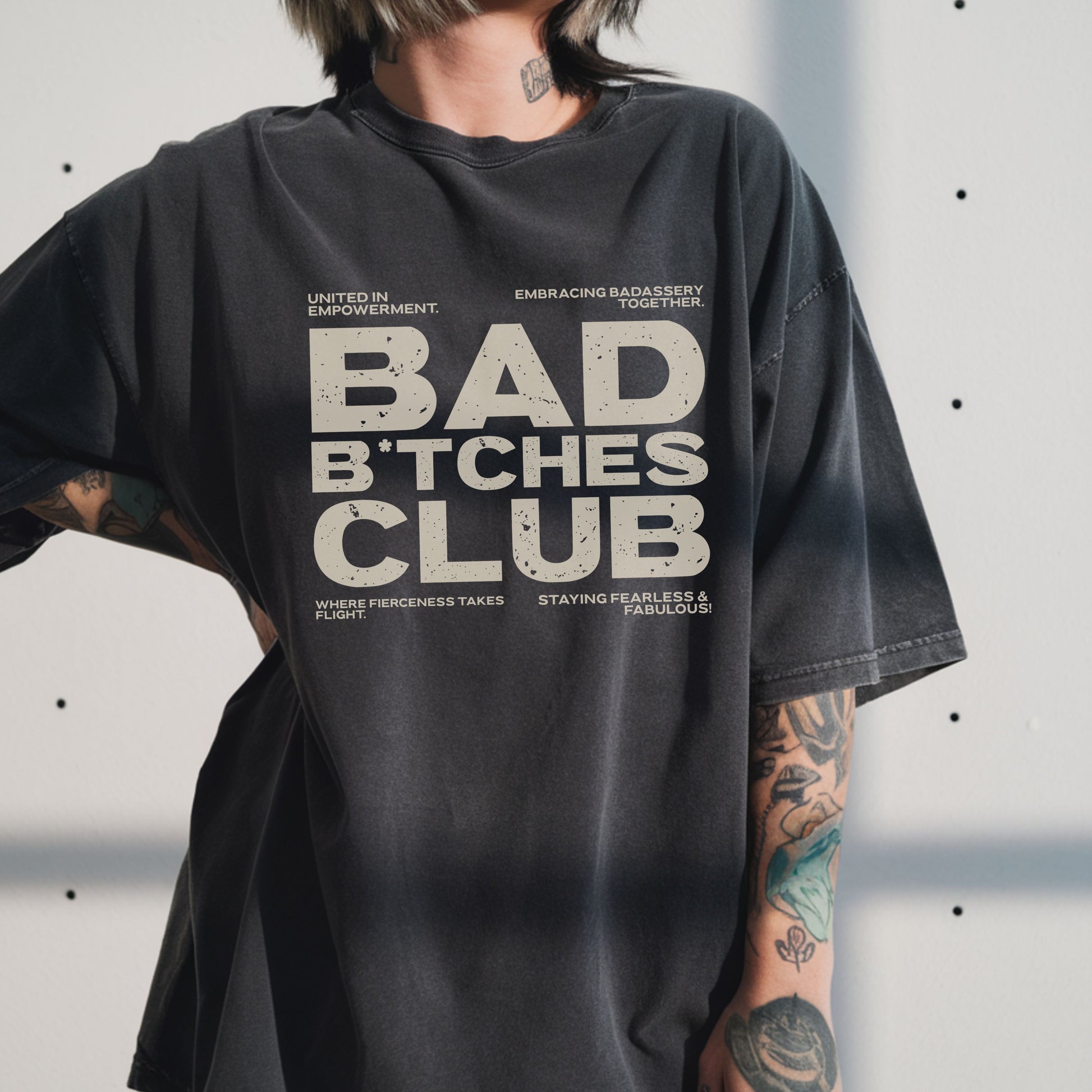 Person wearing a black t-shirt with 'BAD B*CHES CLUB' text design.