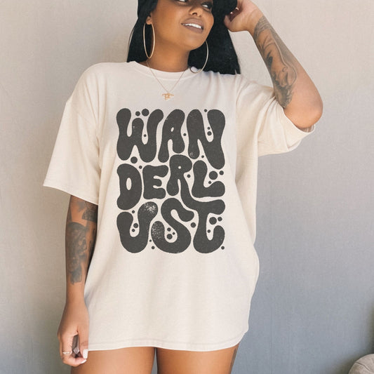 Retro Wanderlust Tee with bold psychedelic font, perfect for travel lovers, free spirits, and adventure seekers. Vintage-inspired graphic t-shirt with groovy lettering and minimalist aesthetic. Oversized fit for a laid-back, casual style. 