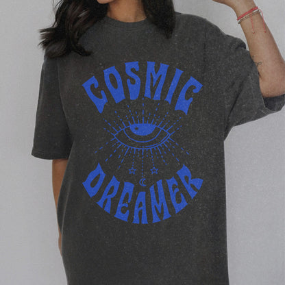 Mystical graphic tee featuring a spiritual eye, cosmic dreamer typography, and celestial design. Perfect for vintage-inspired outfits, boho rebel style, and night sky aesthetics.