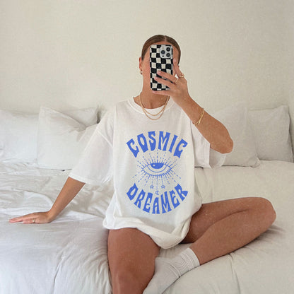 Mystical graphic tee featuring a spiritual eye, cosmic dreamer typography, and celestial design. Perfect for vintage-inspired outfits, boho rebel style, and night sky aesthetics.