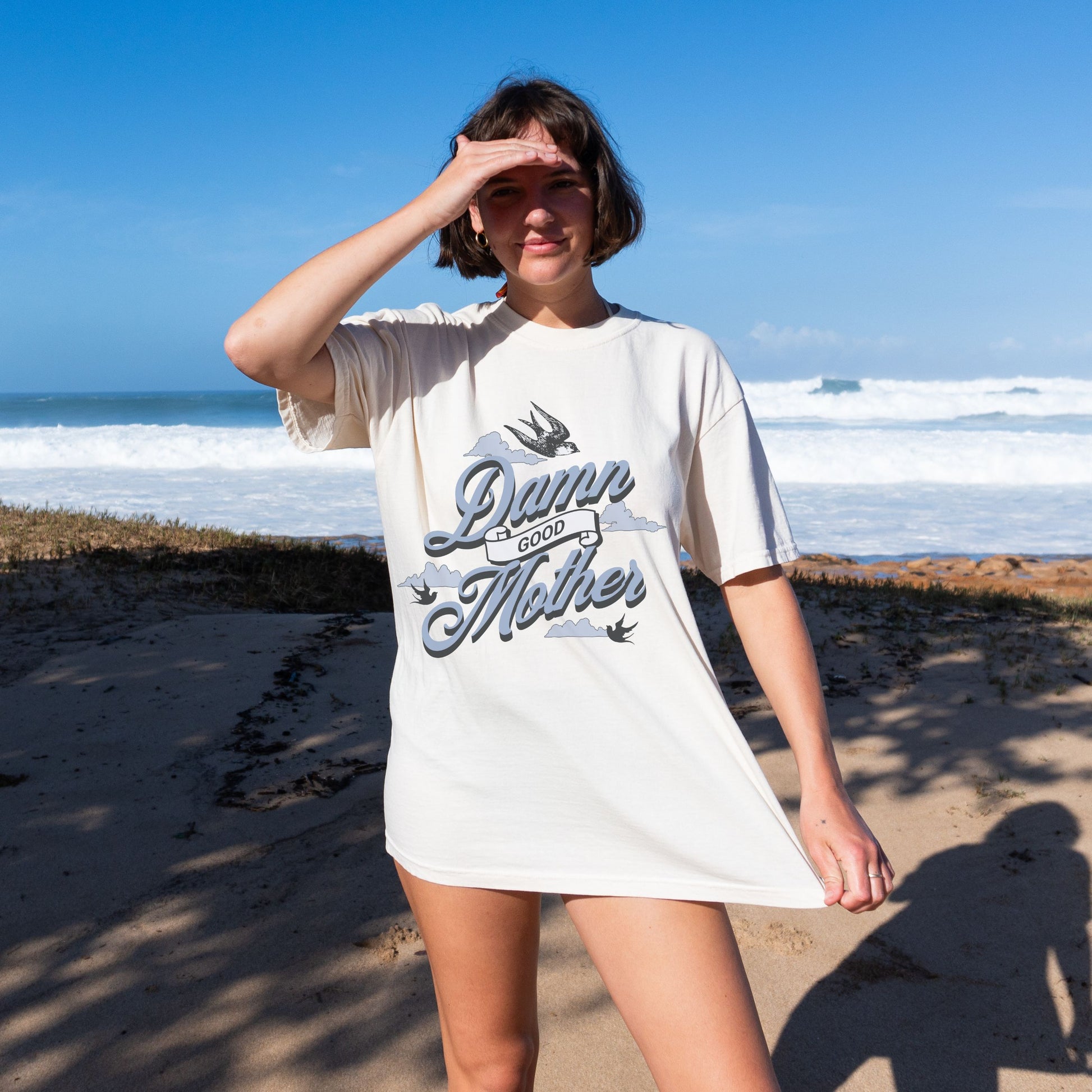 T-shirt with "Damn Good Mother" design in vintage tattoo style. Retro mama t shirt with bold mom statement and bird illustrations. Cool mom graphic tee perfect for Mother’s Day gift or everyday wear. Trendy mom gift tee with edgy mom tee shirt vibes. Stylish mom shirt for confident, fun-loving mamas. Unique cute mom saying tee with rad mama energy. Tattoo style mom tee that makes the perfect bold mom statement piece.