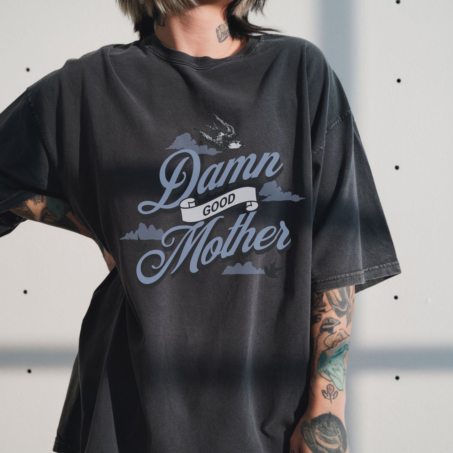 T-shirt with "Damn Good Mother" design in vintage tattoo style. Retro mama t shirt with bold mom statement and bird illustrations. Cool mom graphic tee perfect for Mother’s Day gift or everyday wear. Trendy mom gift tee with edgy mom tee shirt vibes. Stylish mom shirt for confident, fun-loving mamas. Unique cute mom saying tee with rad mama energy. Tattoo style mom tee that makes the perfect bold mom statement piece.