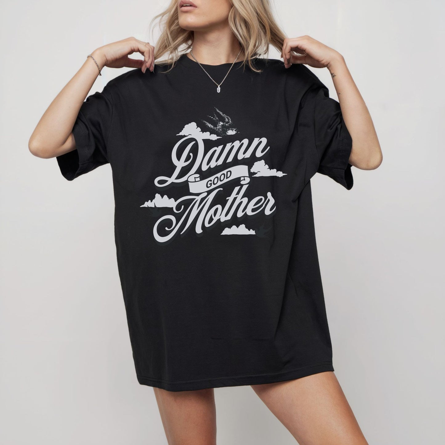 T-shirt with "Damn Good Mother" design in vintage tattoo style. Retro mama t shirt with bold mom statement and bird illustrations. Cool mom graphic tee perfect for Mother’s Day gift or everyday wear. Trendy mom gift tee with edgy mom tee shirt vibes. Stylish mom shirt for confident, fun-loving mamas. Unique cute mom saying tee with rad mama energy. Tattoo style mom tee that makes the perfect bold mom statement piece.