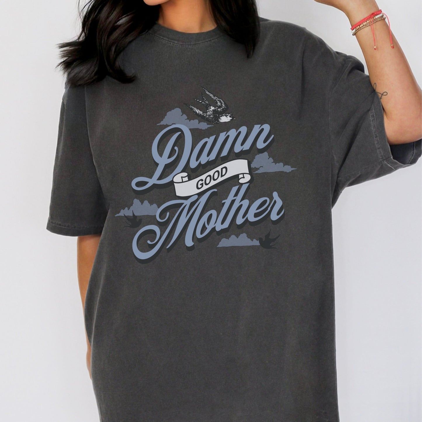 T-shirt with "Damn Good Mother" design in vintage tattoo style. Retro mama t shirt with bold mom statement and bird illustrations. Cool mom graphic tee perfect for Mother’s Day gift or everyday wear. Trendy mom gift tee with edgy mom tee shirt vibes. Stylish mom shirt for confident, fun-loving mamas. Unique cute mom saying tee with rad mama energy. Tattoo style mom tee that makes the perfect bold mom statement piece.