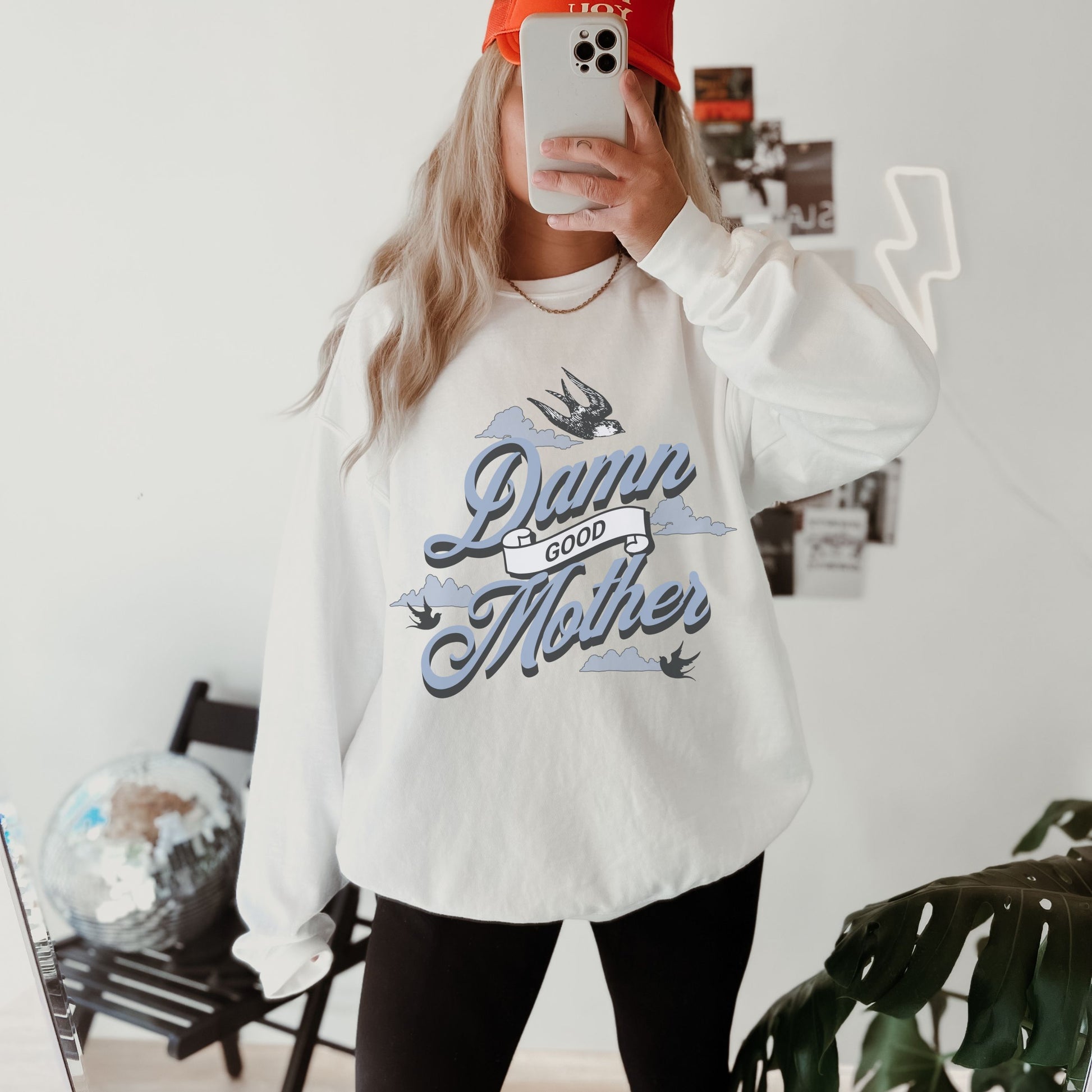 Crewneck sweatshirt with “Damn Good Mother” graphic in tattoo style. Cool mom sweatshirt with vintage and retro mama sweater vibe. Bold mom pullover for edgy, confident women. Funny mom jumper and trendy mom sweater perfect for gifting or everyday wear. Stylish mama crew with rad mom graphic top. Great for Mother's Day crewneck gift or casual looks. Cute mom sweatshirt with bold statement and timeless design.
