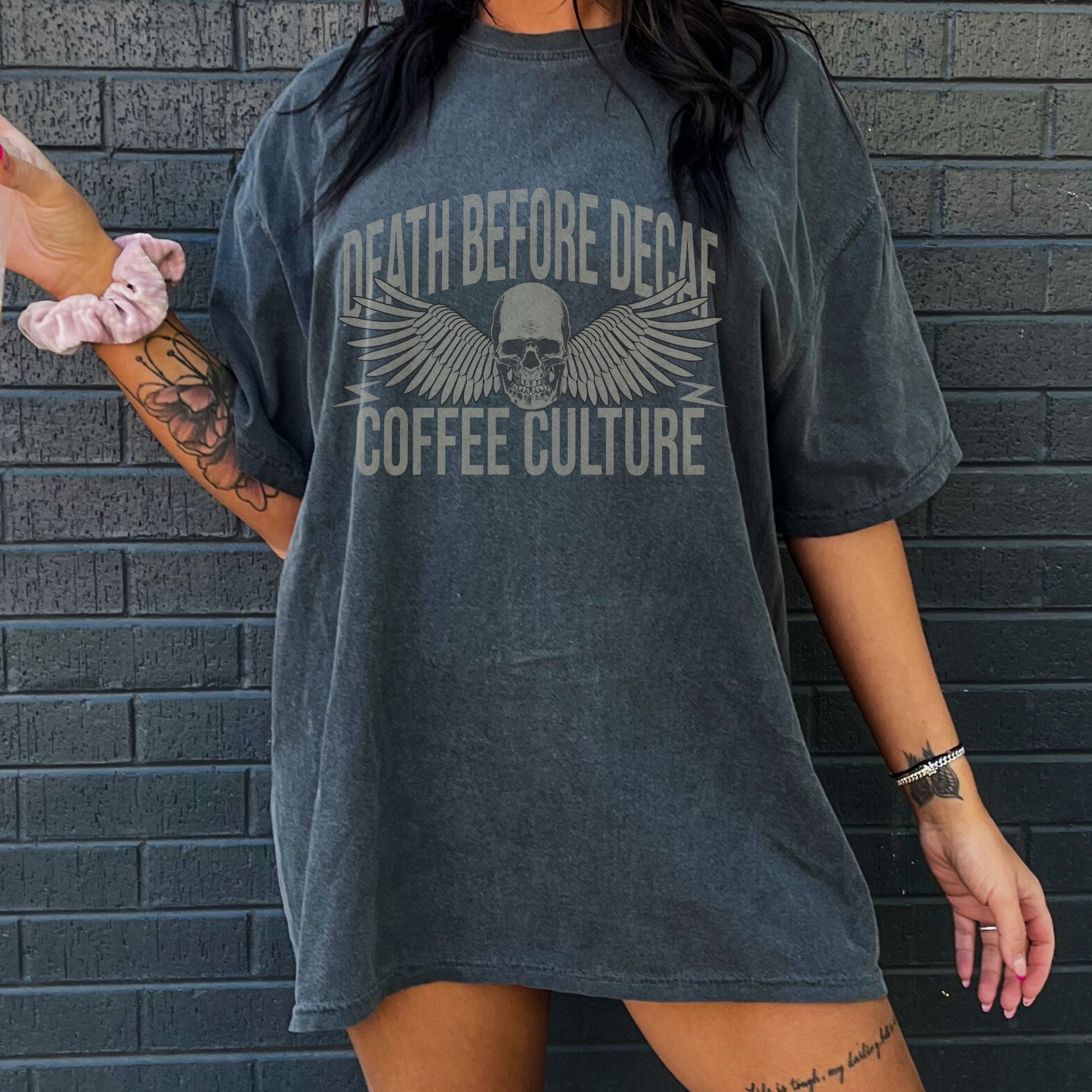 T-shirt with bold Death Before Decaf design featuring a skull and wings. Perfect for coffee lovers who prefer strong brews. This edgy coffee skull shirt makes a great caffeine addict tee or anti decaf shirt. Fits unisex style and works as a vintage coffee tee, goth coffee shirt, or strong coffee shirt. Ideal for casual wear, gifting, or making a bold coffee culture statement. Funny coffee shirt with attitude.
