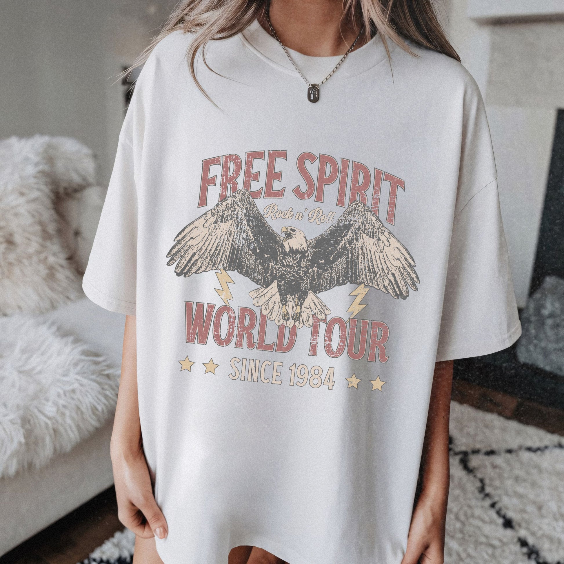 Vintage tour shirt with eagle graphic, distressed details, and 1984 band tour text, perfect for lovers of retro graphic tees, rock and roll shirts, and oversized styles. Casual vintage tee with bold lightning bolt accents.