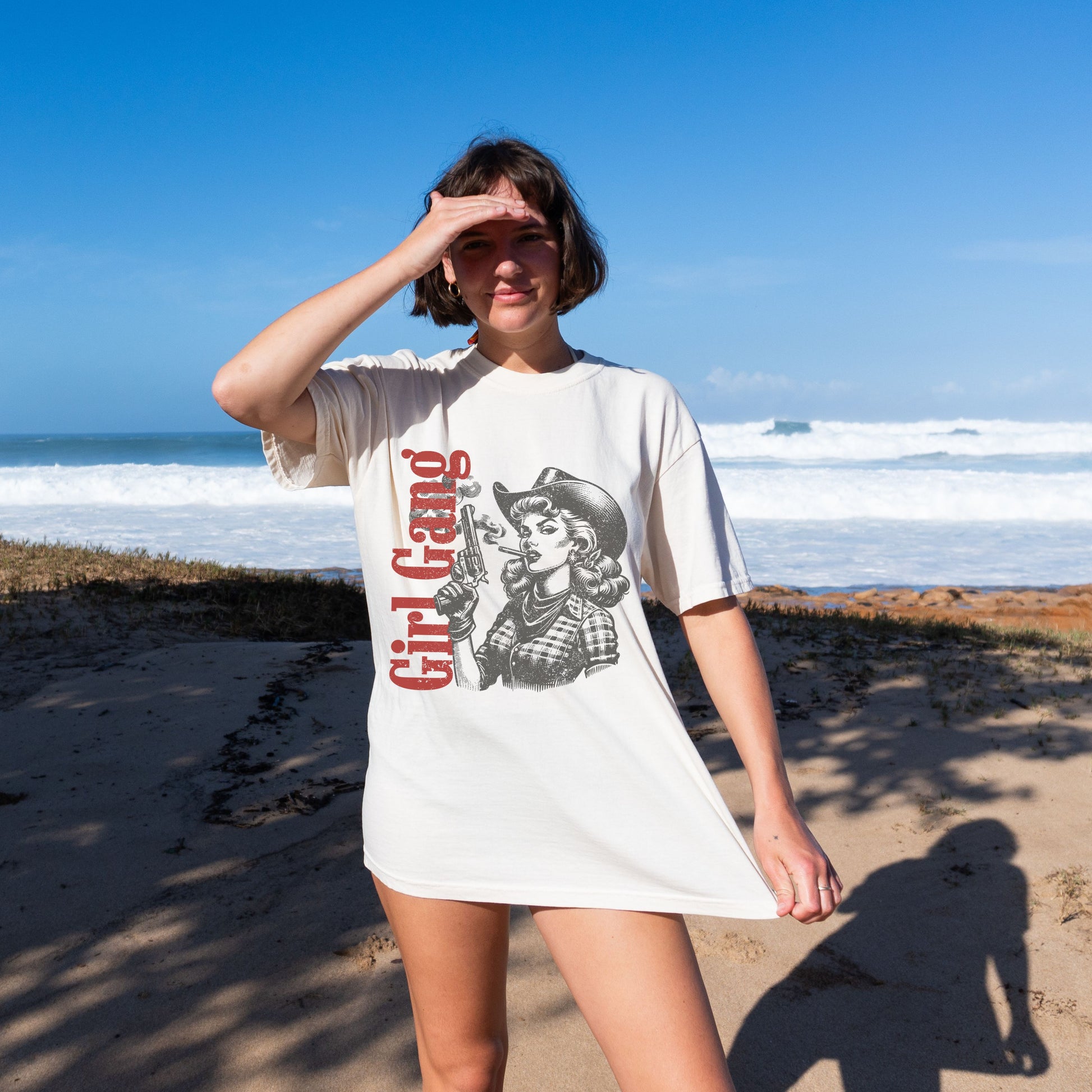 Woman wearing a 'Girl Gang' t-shirt on a beach
