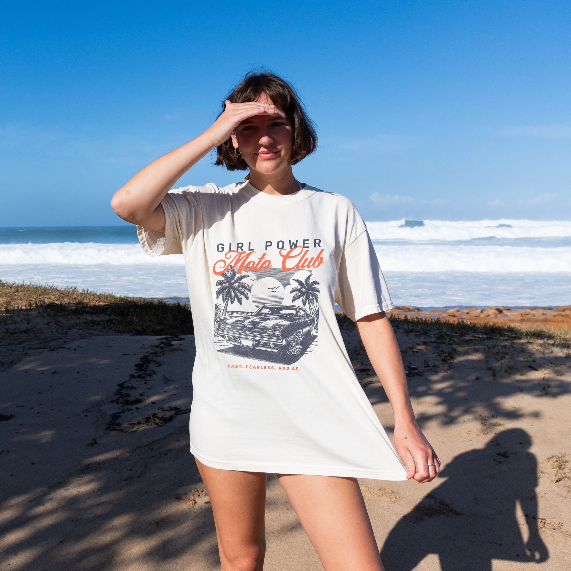 Woman wearing a 'Girl Power Auto Club' t-shirt on a beach