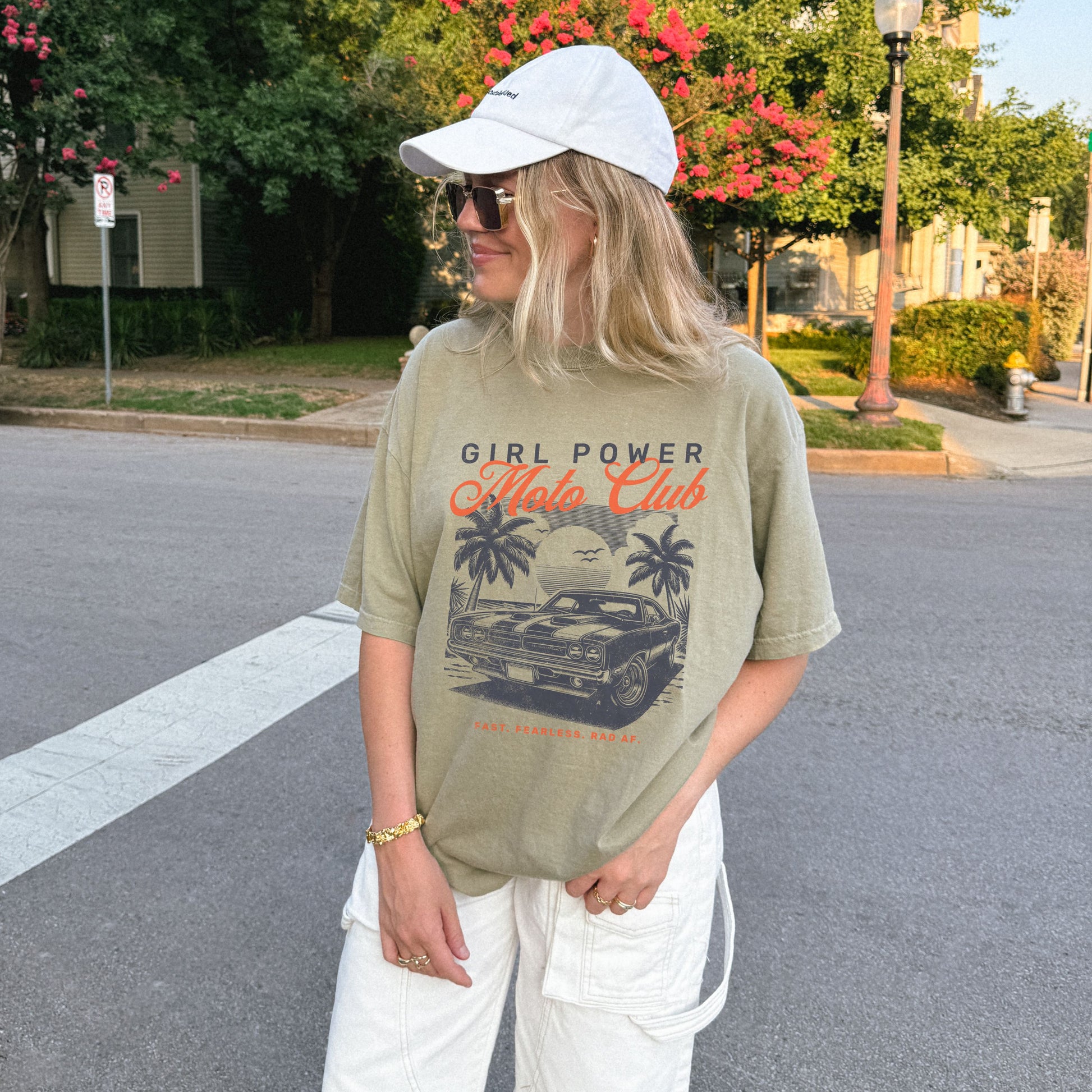 Person wearing a 'Girl Power Hot Rods Club' t-shirt on a street.
