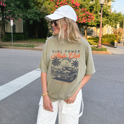 Person wearing a 'Girl Power Hot Rods Club' t-shirt on a street.