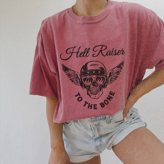 Graphic tee featuring a vintage-inspired winged skull and helmet design. Perfect for fans of retro biker style, rebel looks, and distressed rocker shirts. A badass, edgy option for casual wear with a unique skull and wings design.