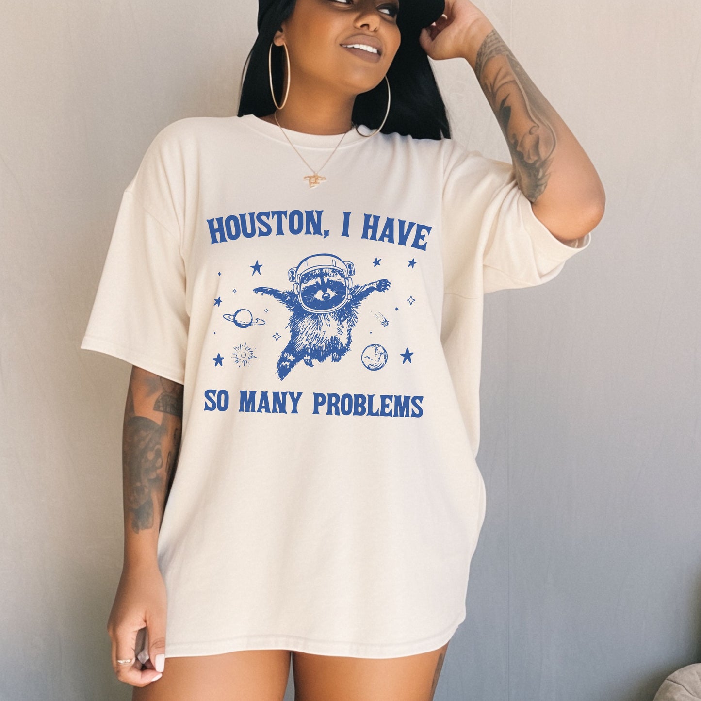 Person wearing a white t-shirt with blue text and graphics against a plain background