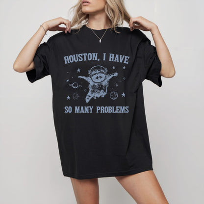 Black t-shirt with humorous graphic and text worn by a model on a plain background