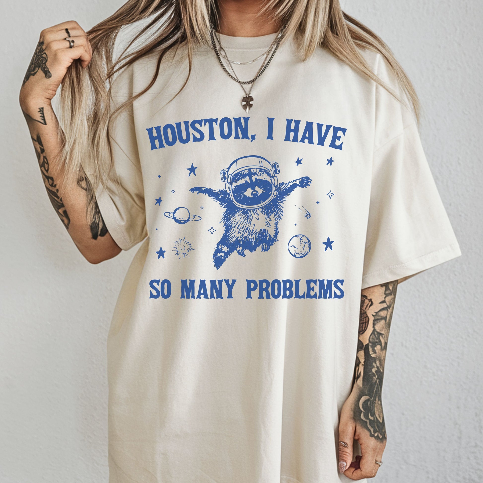 Person wearing a white t-shirt with a blue graphic and text on a plain background