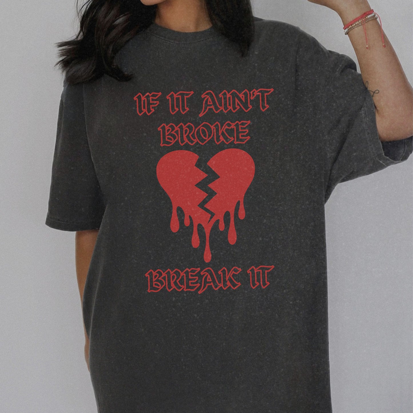 T-shirt with bold gothic-style text 'If It Ain't Broke, Break It' and dripping broken heart graphic. Perfect for rebellious fashion, Valentine’s Day outfit ideas, edgy streetwear style, and bold statement graphic tees.