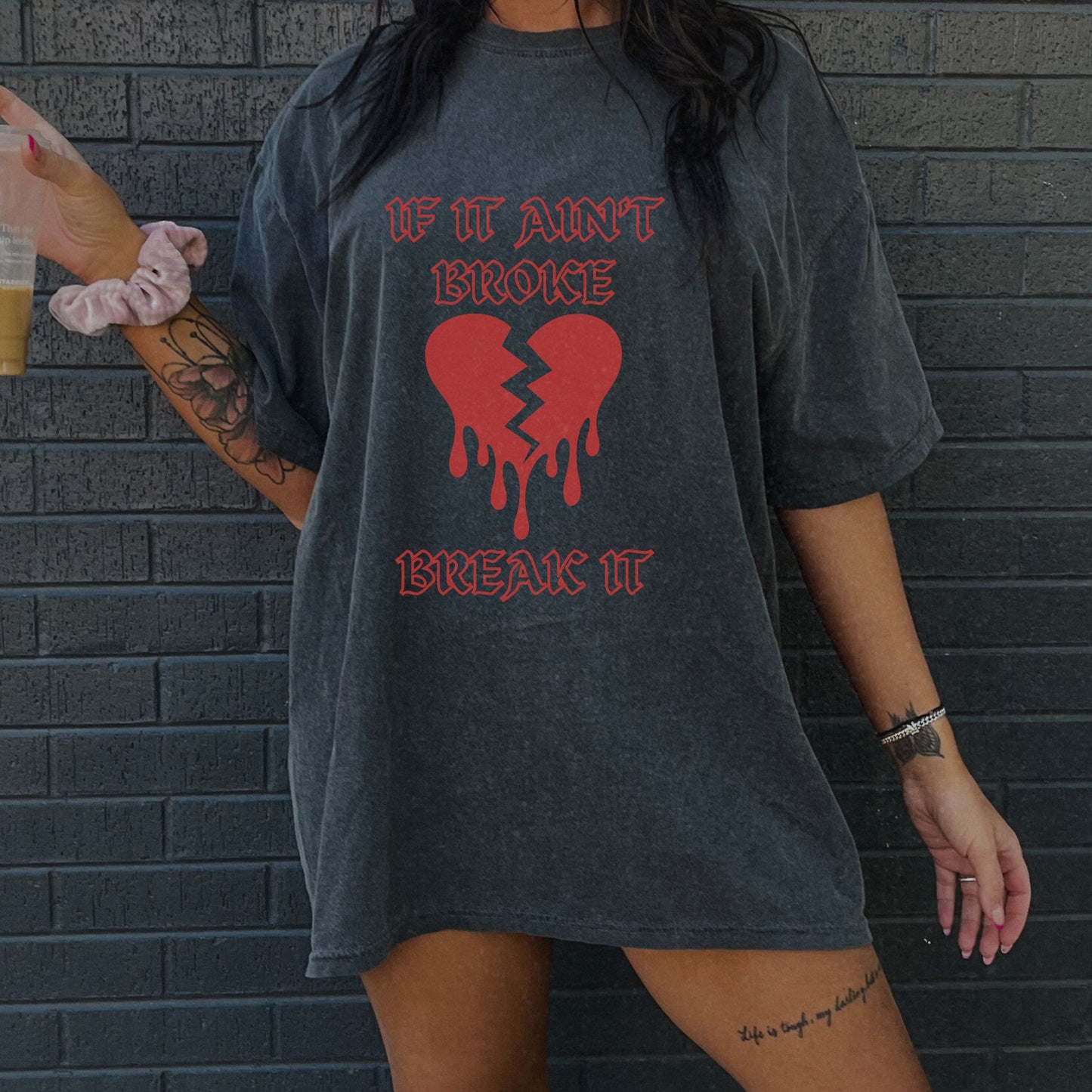 T-shirt with bold gothic-style text 'If It Ain't Broke, Break It' and dripping broken heart graphic. Perfect for rebellious fashion, Valentine’s Day outfit ideas, edgy streetwear style, and bold statement graphic tees.