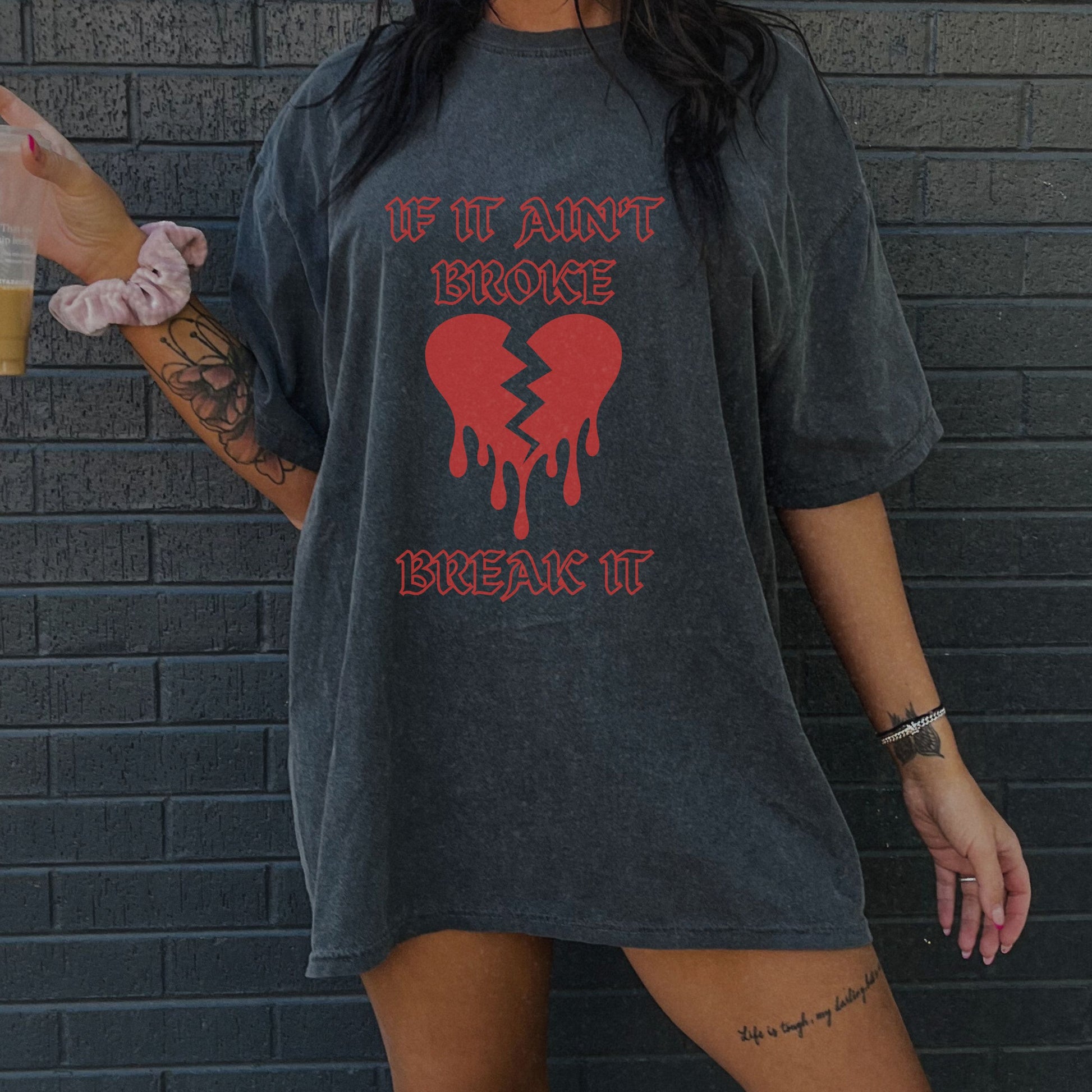 T-shirt with bold gothic-style text 'If It Ain't Broke, Break It' and dripping broken heart graphic. Perfect for rebellious fashion, Valentine’s Day outfit ideas, edgy streetwear style, and bold statement graphic tees.