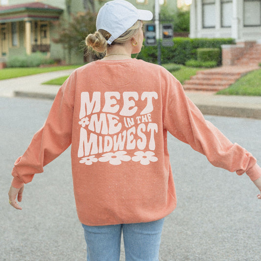 Crewneck sweatshirt with bold "Meet Me in the Midwest" typography and floral design. Perfect for casual outfits, relaxed weekends, or road trips. Oversized fit offers trendy, comfortable style for everyday wear.