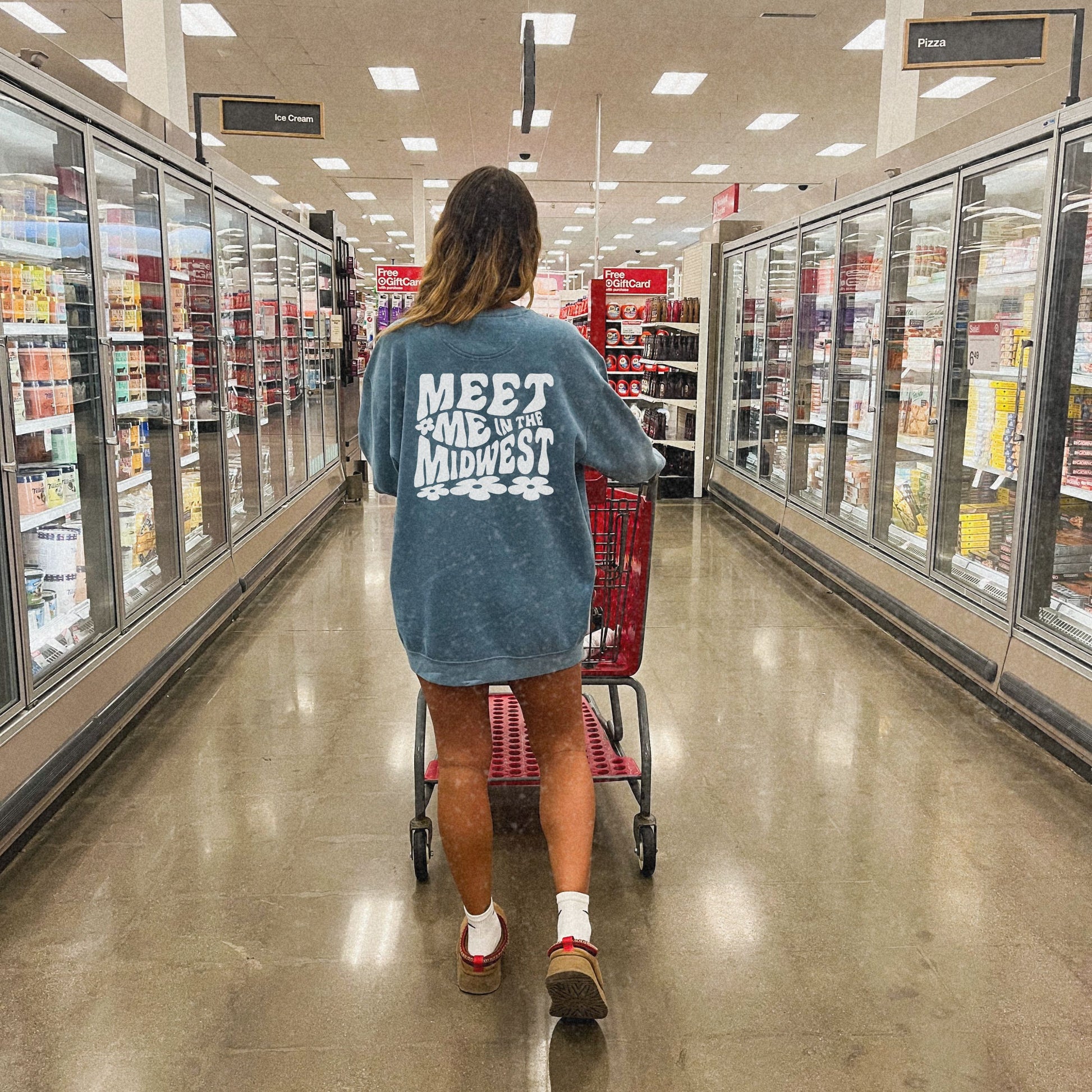 Crewneck sweatshirt with bold "Meet Me in the Midwest" typography and floral design. Perfect for casual outfits, relaxed weekends, or road trips. Oversized fit offers trendy, comfortable style for everyday wear.