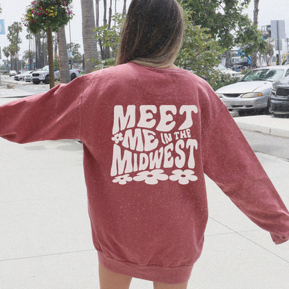 Crewneck sweatshirt with bold "Meet Me in the Midwest" typography and floral design. Perfect for casual outfits, relaxed weekends, or road trips. Oversized fit offers trendy, comfortable style for everyday wear.