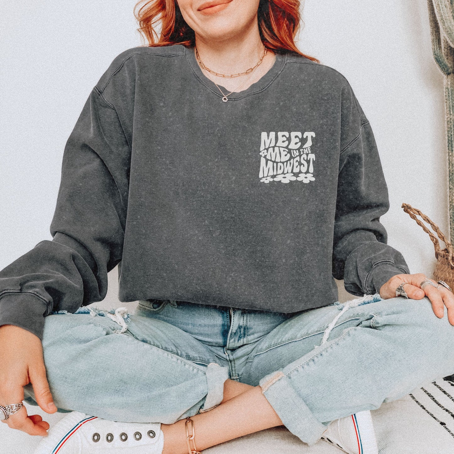 Crewneck sweatshirt with bold "Meet Me in the Midwest" typography and floral design. Perfect for casual outfits, relaxed weekends, or road trips. Oversized fit offers trendy, comfortable style for everyday wear.