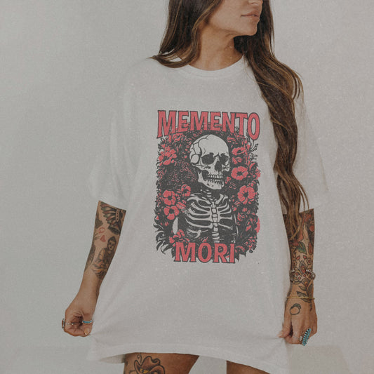 Graphic tee featuring a detailed skull design surrounded by floral elements, perfect for fans of vintage skeleton tees, gothic skull shirts, and retro goth style. A trendy death-themed shirt combining dark floral and skeleton art for casual or streetwear looks.