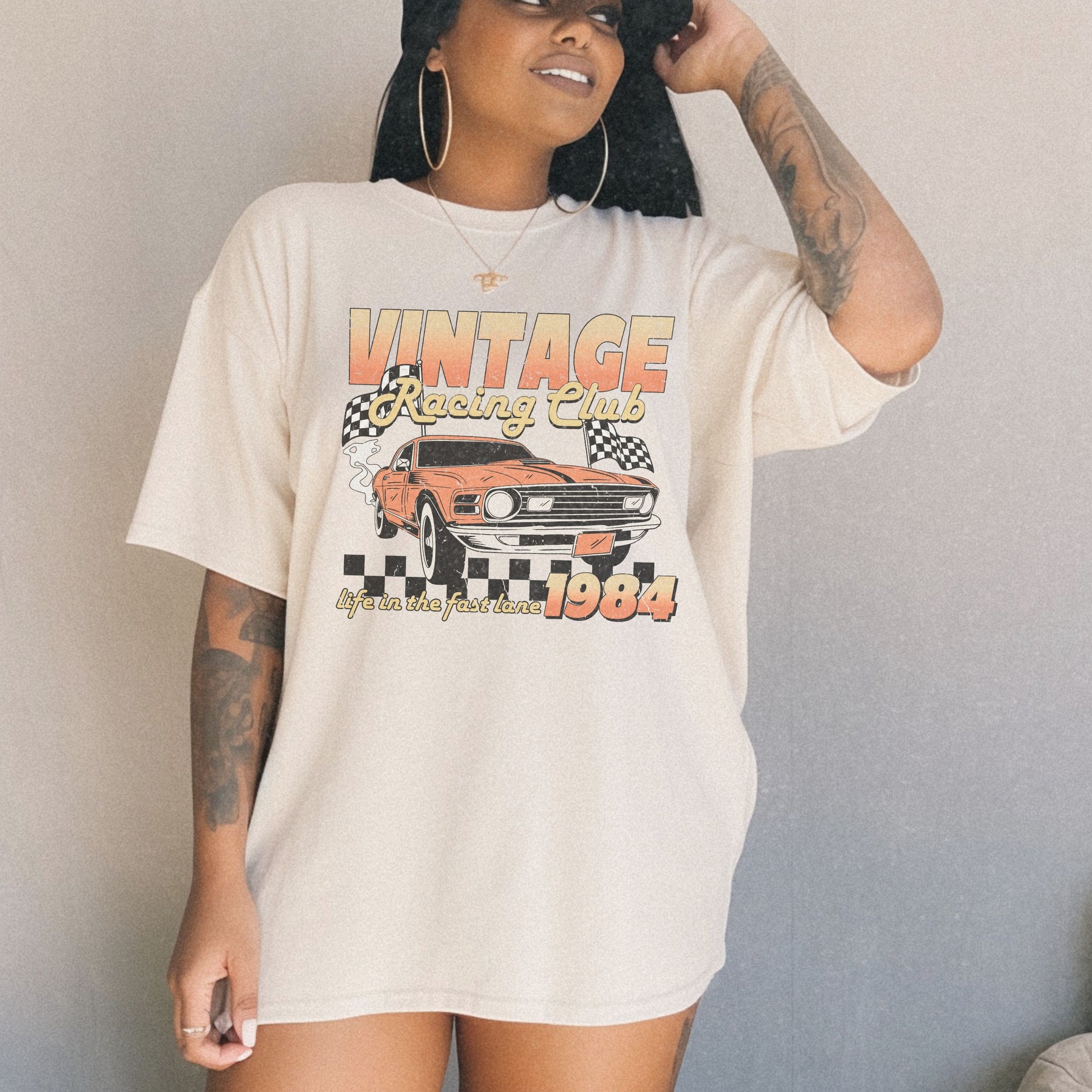 Retro racing T-shirt featuring a bold 1984 vintage design with distressed car graphics. Perfect nostalgic car shirt for muscle car lovers, featuring checkered flag details. Ideal for fans of old school racing and fast lane graphic tees.