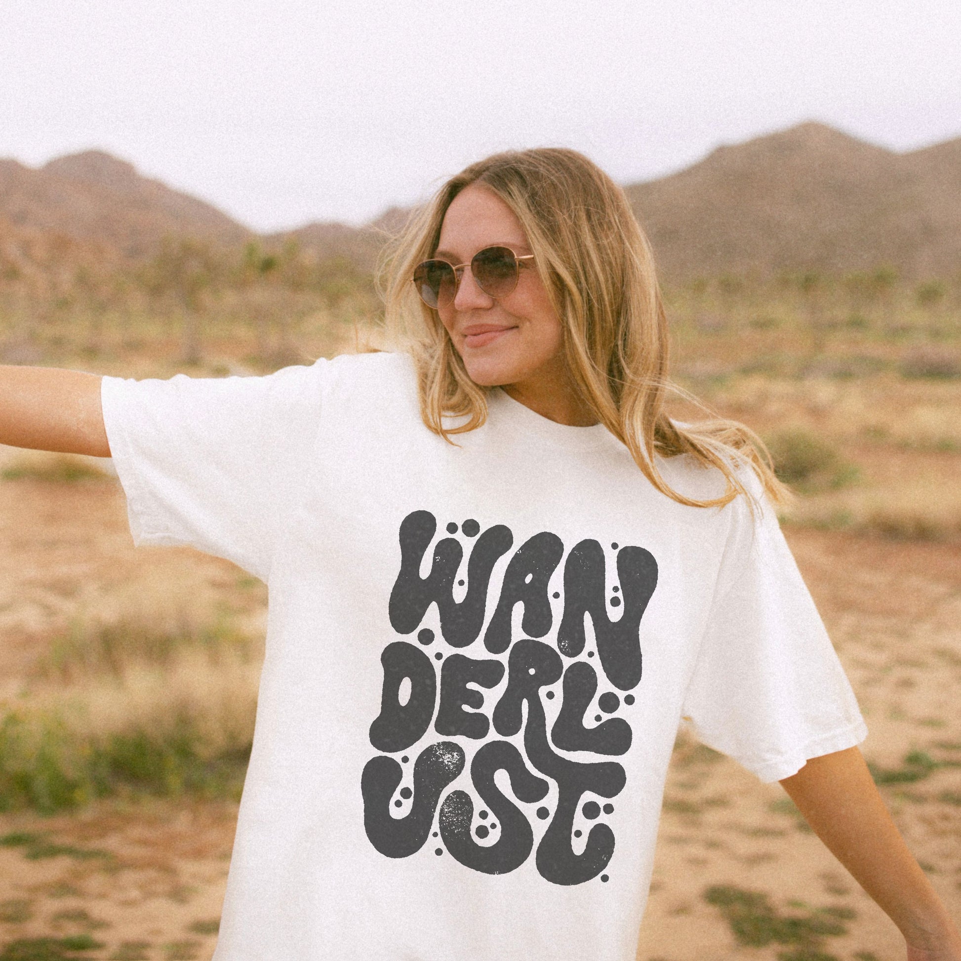Retro Wanderlust Tee with bold psychedelic font, perfect for travel lovers, free spirits, and adventure seekers. Vintage-inspired graphic t-shirt with groovy lettering and minimalist aesthetic. Oversized fit for a laid-back, casual style. 