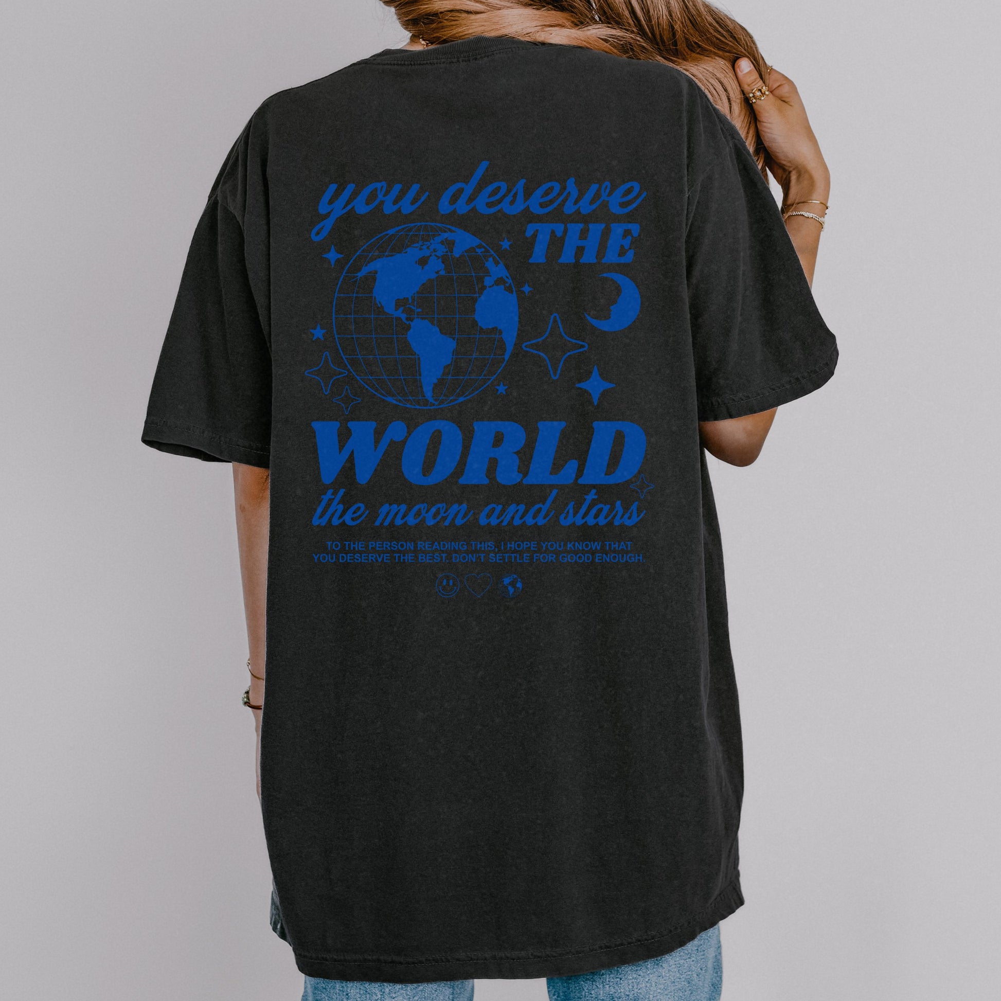 Motivational graphic t-shirt with a celestial design featuring stars, moon, and globe. Includes the inspiring phrase 'you deserve the world.' A trendy and stylish vintage-inspired tee for casual wear, perfect for spreading positivity and empowerment.