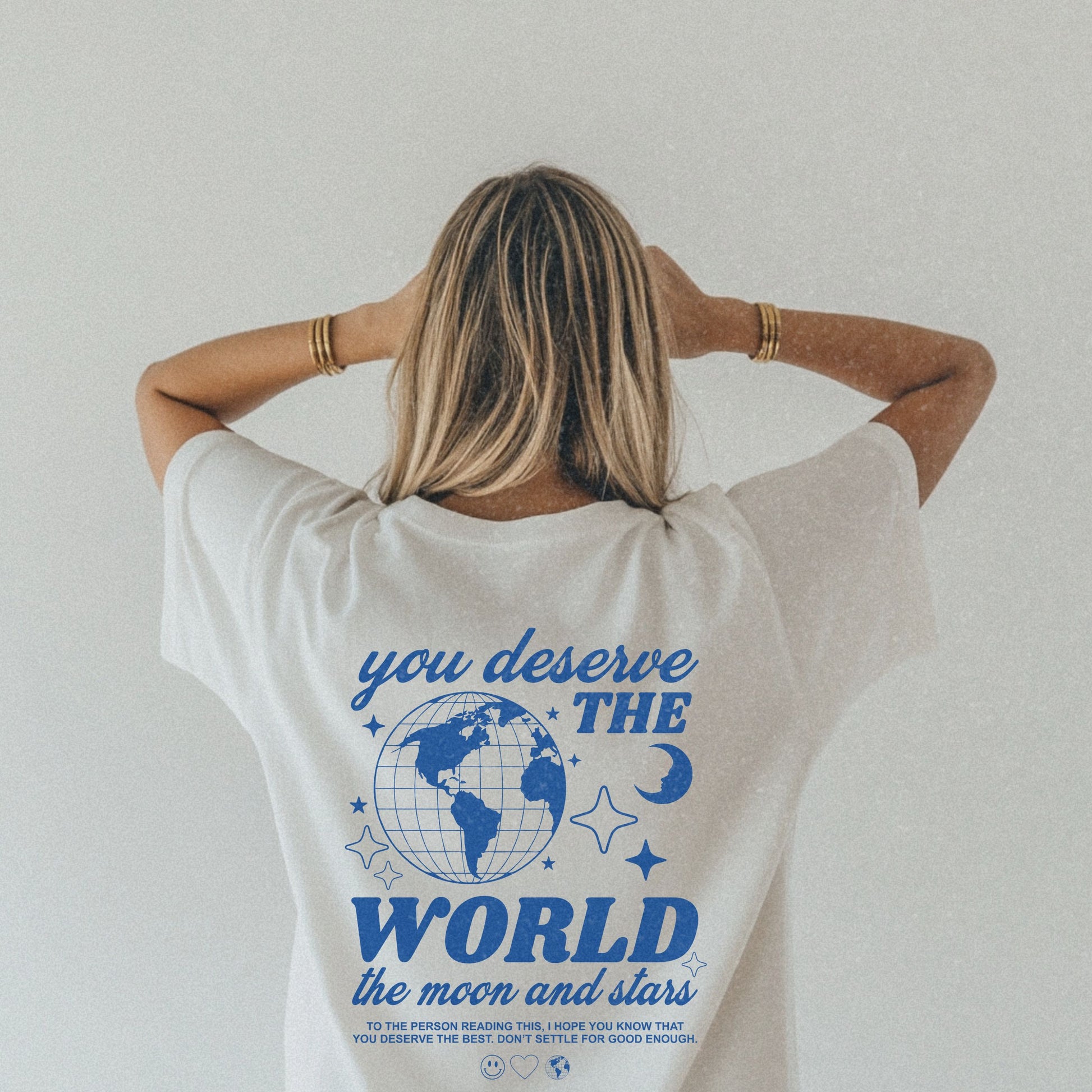Motivational graphic t-shirt with a celestial design featuring stars, moon, and globe. Includes the inspiring phrase 'you deserve the world.' A trendy and stylish vintage-inspired tee for casual wear, perfect for spreading positivity and empowerment.