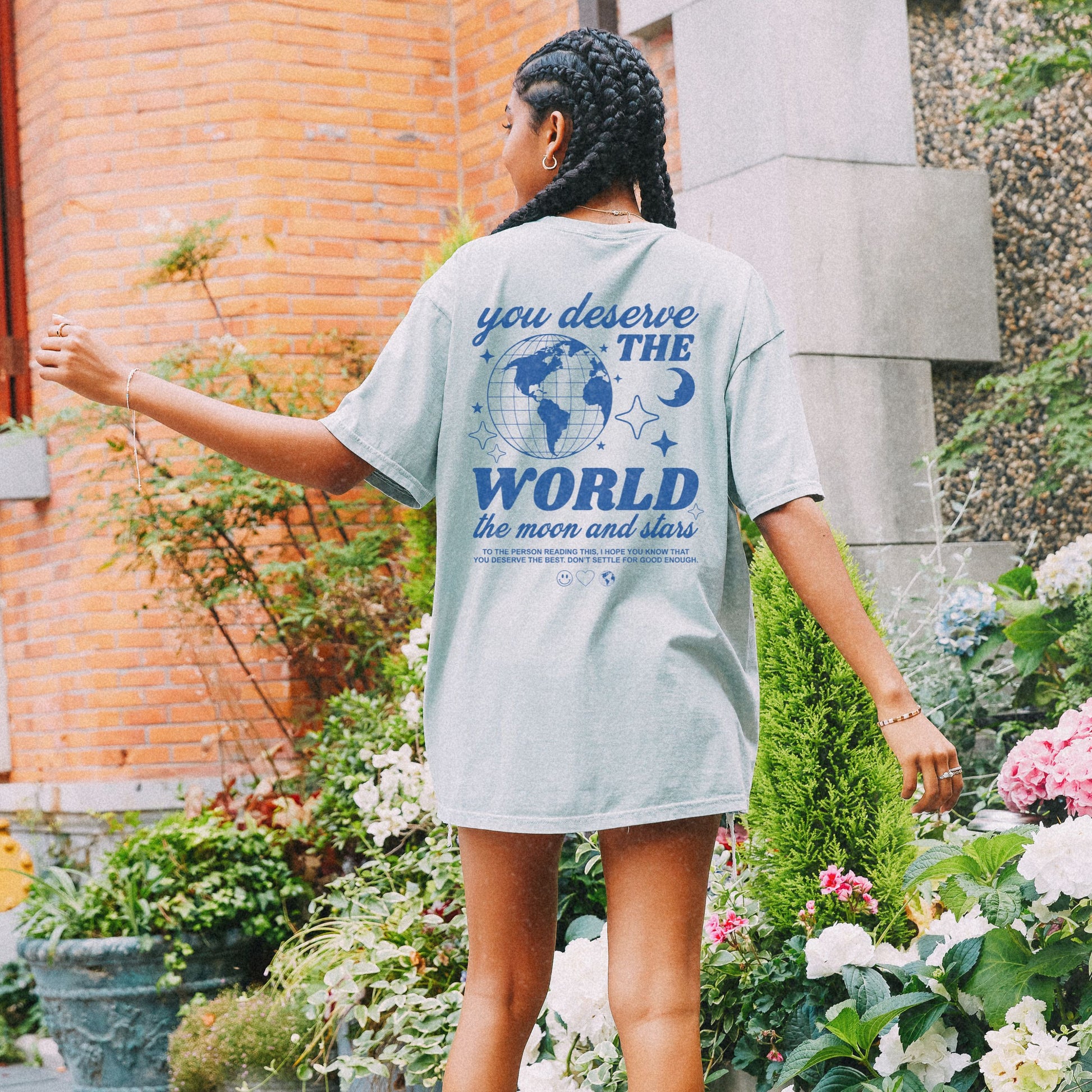 Motivational graphic t-shirt with a celestial design featuring stars, moon, and globe. Includes the inspiring phrase 'you deserve the world.' A trendy and stylish vintage-inspired tee for casual wear, perfect for spreading positivity and empowerment.